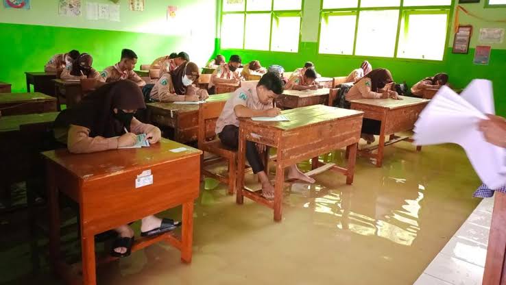 Sedih, Siswa SMP di Mojokerto Terpaksa Kerjakan Ujian Akhir Sekolah di Tengah Banjir